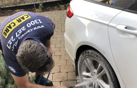 Applying wheel cleaner with a Soda Blaster to white Ford alloy wheels